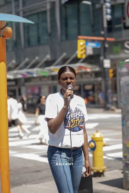 A worshipper singing on a downtown Toronto street during Gospel in the City
